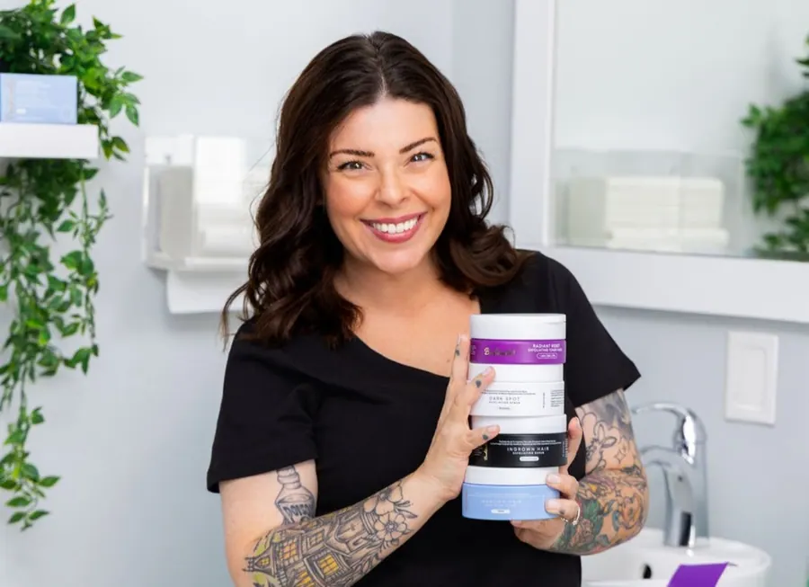 Your esthetician holding professional skincare and aftercare products in the studio