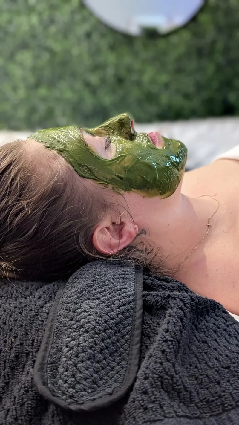 Client relaxing with a green facial mask
